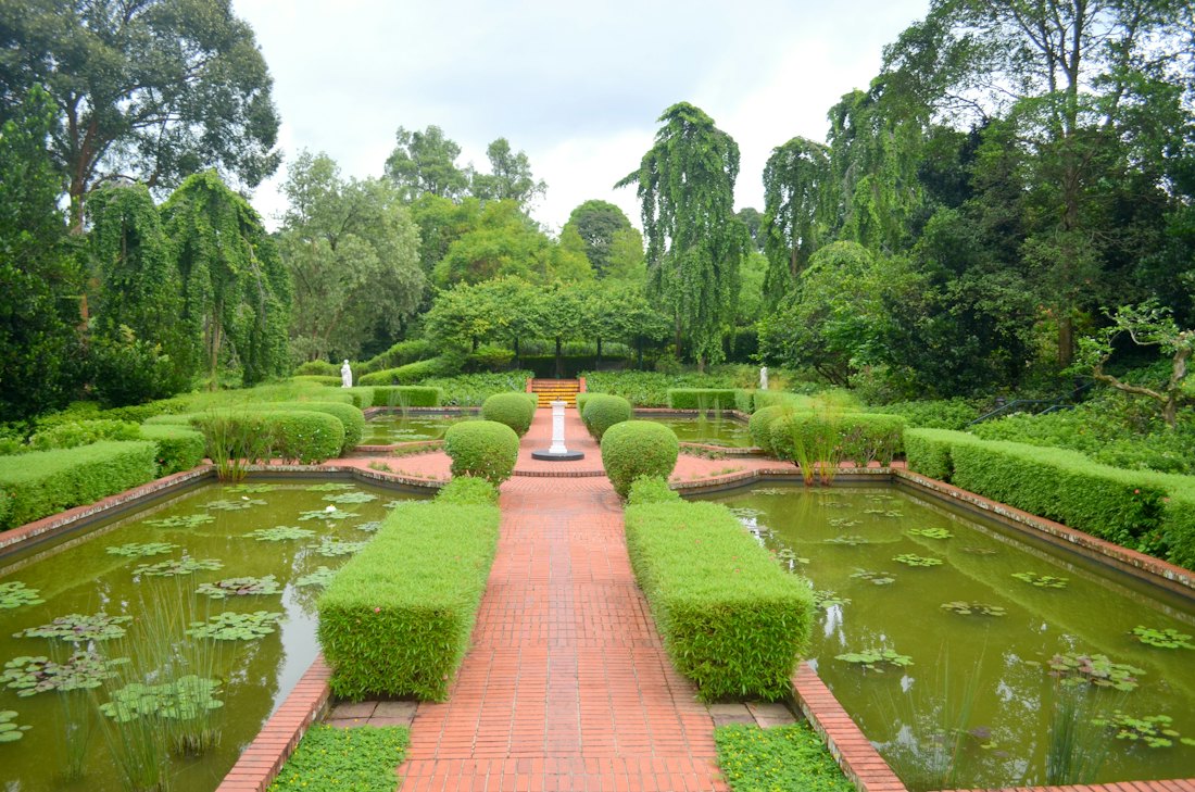 Gepflästeter Weg mit Brunnen und Gartenanlage